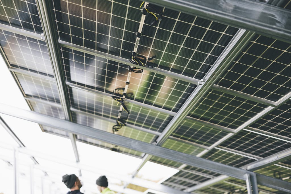 Close-up of solar panels being installed outdoors with technicians visible.